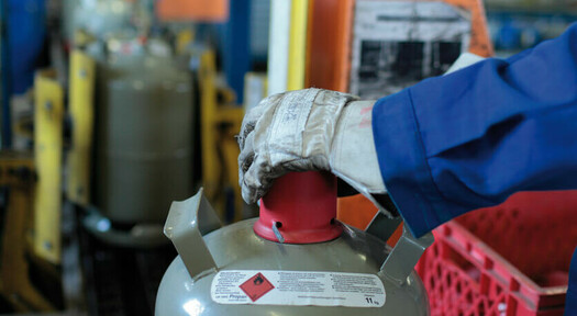 Sicherung einer 11 kg Eigentumsflasche mit roter Verschlusskappe nach dem Befüllen, zum sicheren Transport.