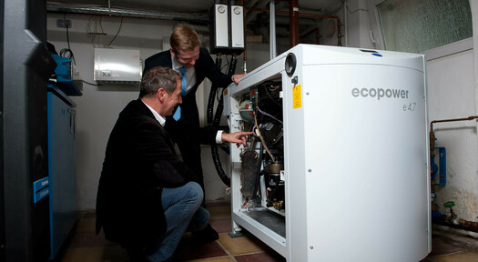 Zwei Rheingas-Experten beim Begutachten eines Blockheizkraftwerkes im Keller.