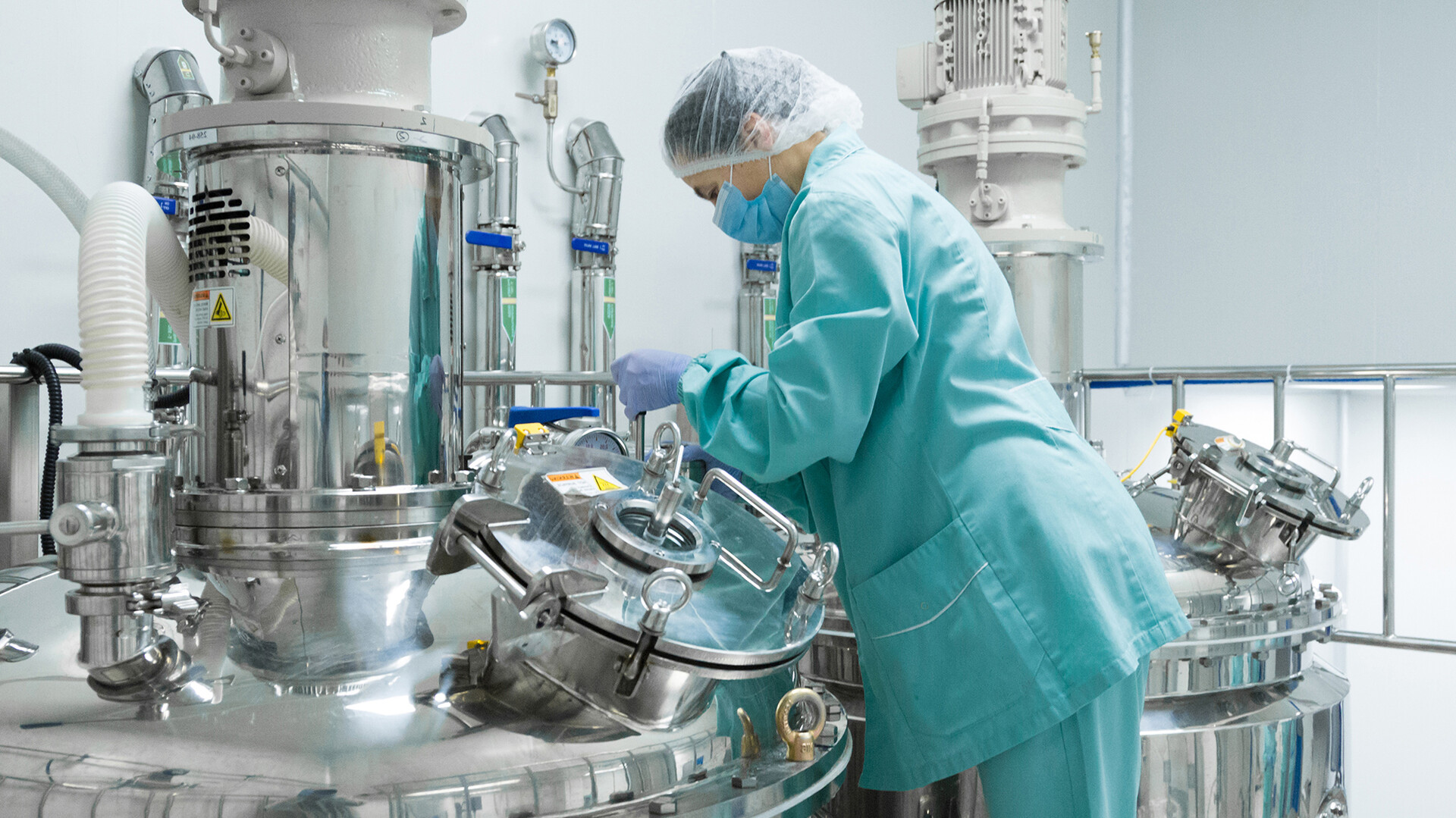 Frau arbeitet unter sterilen Bedingungen in der Produktion eines Pharmaunternehmens, welches Flüssiggas als Prozessenergie nutzt.