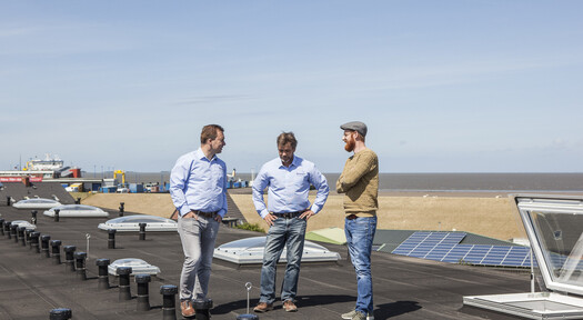 Rheingas Vertriebsmitarbeiter, der Kunden auf einem Dach zu einer PV-Anlage berät