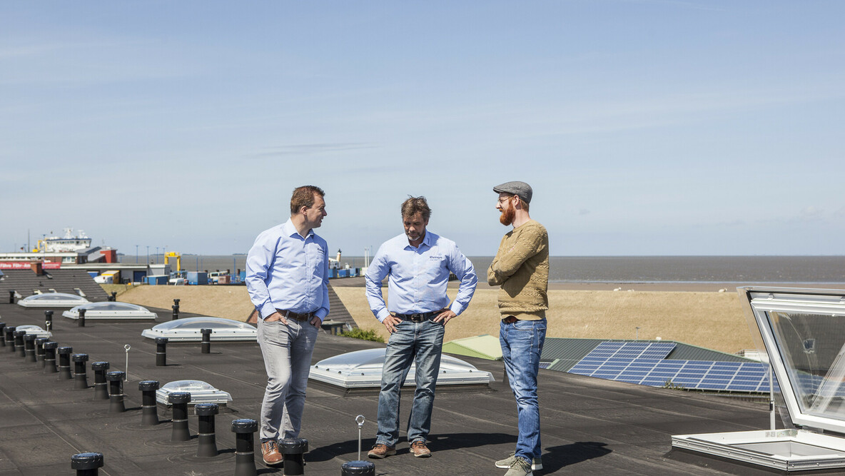 Rheingas Vertriebsmitarbeiter, der Kunden auf einem Dach zu einer PV-Anlage berät