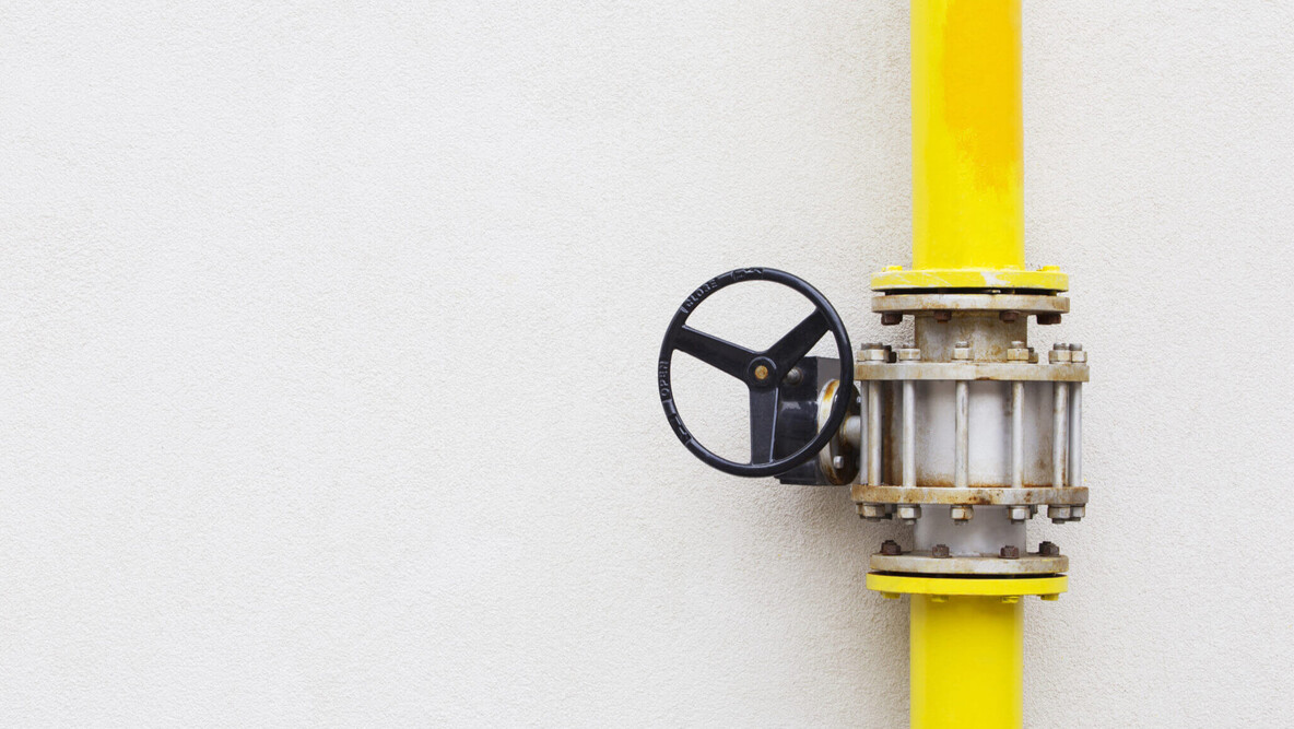 Gelbe Gasleitung vor einer Hauswand durch die Erdgas oder Flüssiggas fließen kann.