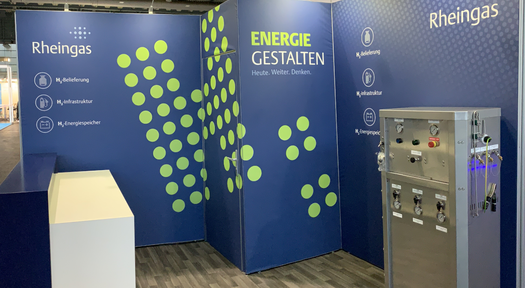 Blau-grüner Rheingas-Messestand mit Wasserstoff-Zapfsäule auf der Hydrogen Technology Expo Europe 2022 in Bremen.