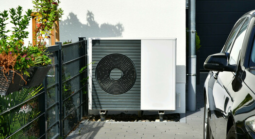 Luft-Luft Wärmepumpe in der Einfahrt eines Hauses, die durch eine Flüssiggasheizung unterstützt werden kann.