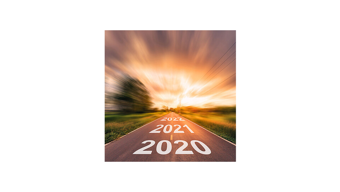 Eine Straße die Richtung Sonnenuntergang führt und die Jahre 2020, 2021 und 2022 in weißer Farbe auf dem Asphalt trägt.