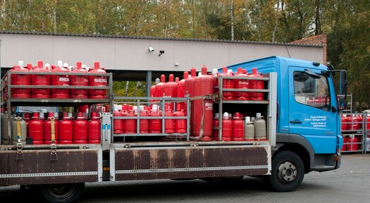 Sicherer Transport roter 33 kg Gasflaschen von Rheingas auf einem LKW.