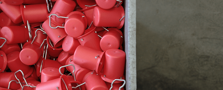 Rote Ventilschutzkappen für Gasflaschen in einem Container.